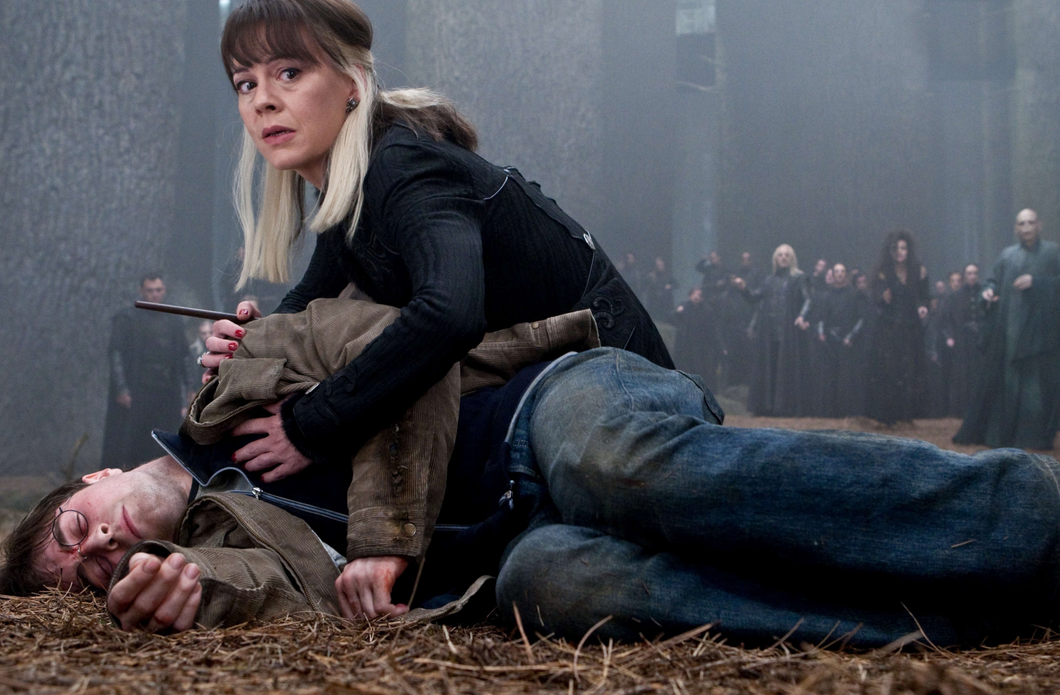 Narcissa Malfoy crouching next to Harry's dead body.